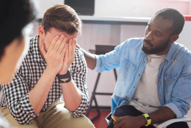 a man with his head in his hands wondering what is trauma-informed care