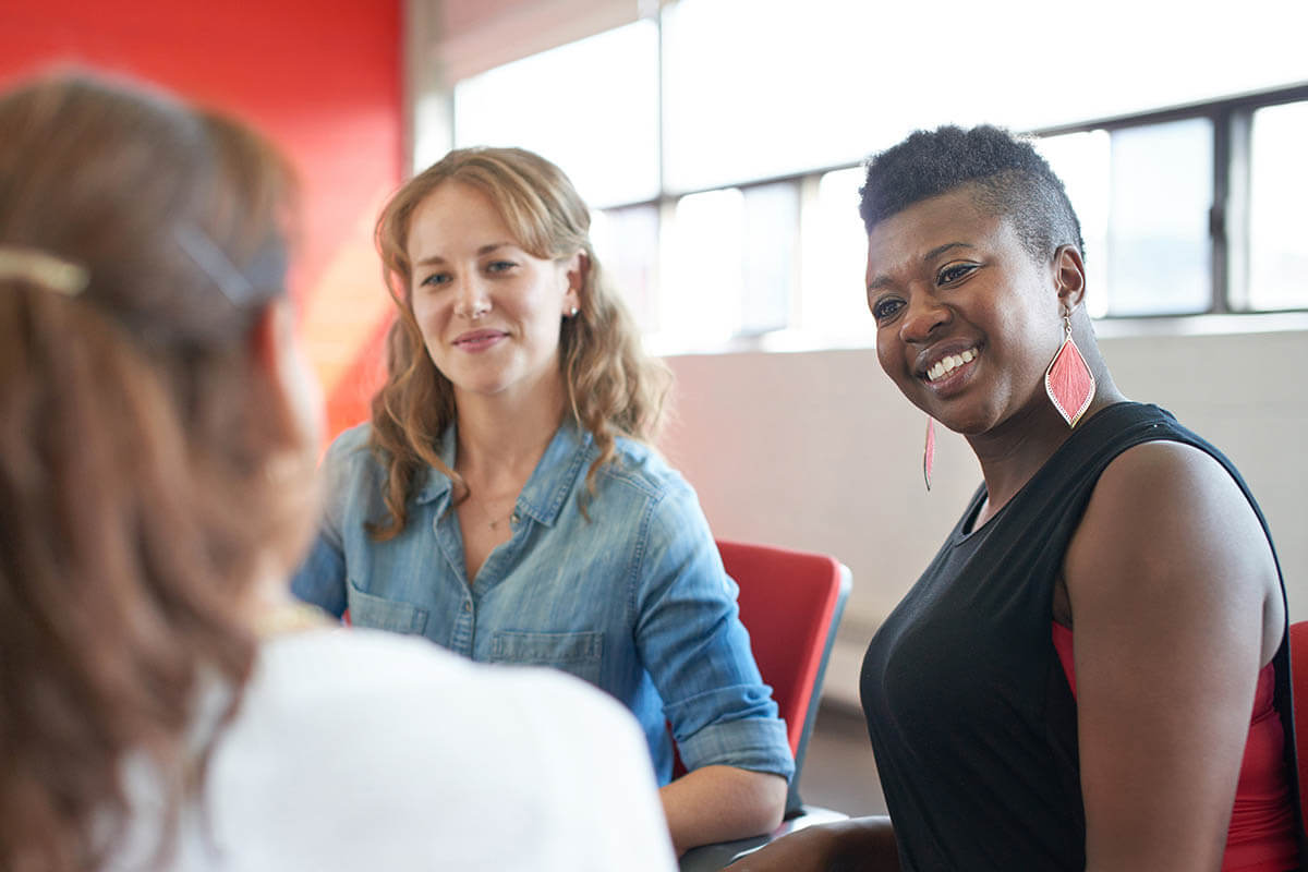 women smiling in group therapy in an alcohol and drug rehab