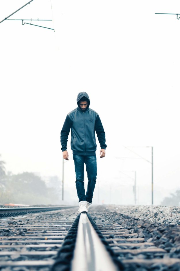 pexels-chinmay-singh-843563 man walking on tracks (free photo)