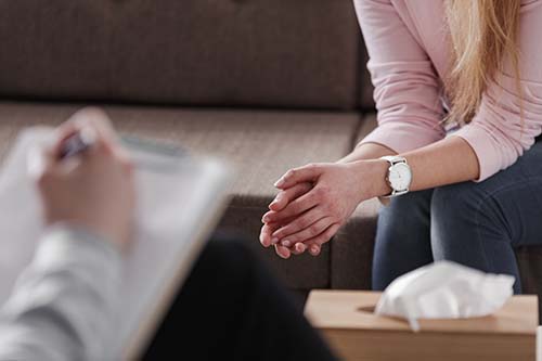 woman with folded hands in an individual therapy session as part of dual diagnosis treatment
