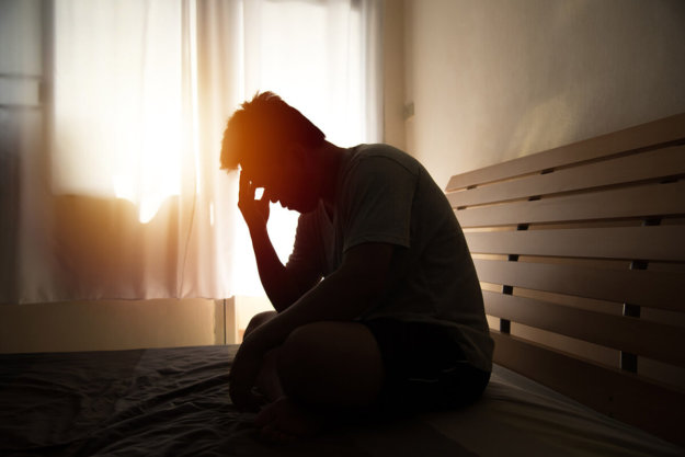 Long-Term Effects of Heroin Desperate man sits on bench as light streams through window contemplating long-term effects of heroin