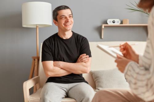 smiling man in an individual counseling session in a drug detox center