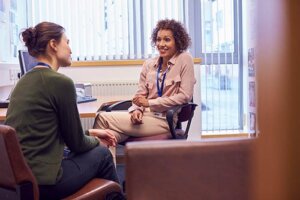 woman talks with therapist in an aftercare program