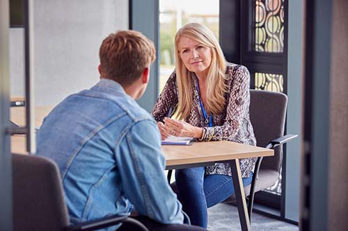 woman talks with therapist in a dialectical behavior therapy group