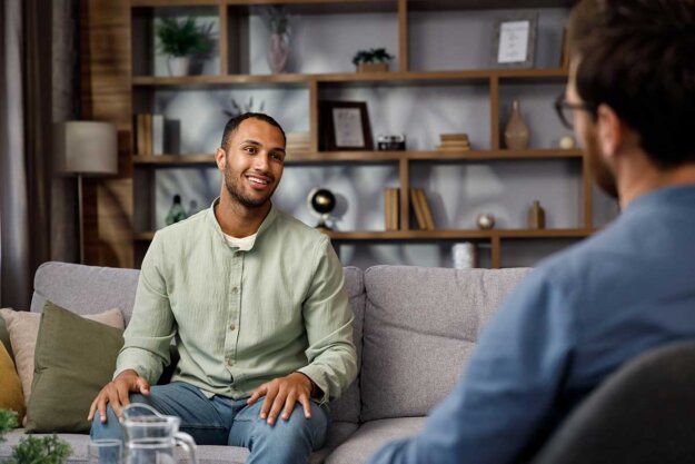 How-Outpatient-Rehab-Helps-with-Long-Term-Recovery (1) man talks with therapist about how outpatient rehab helps with long-term recovery