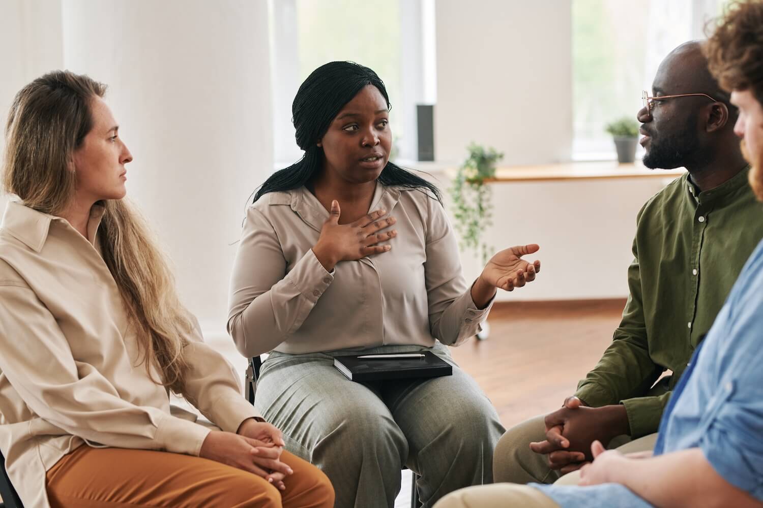 Addiction Treatment After Detox Why Recovery Requires More Than Detox Alone Diverse group of people in a therapy circle sharing experiences during an addiction recovery meeting