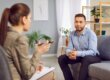 Therapist speaking with a man during an addiction recovery consultation in a modern office
