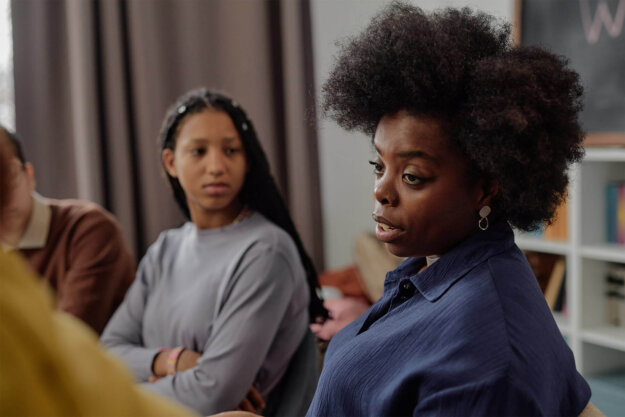 Black woman speaking in group therapy