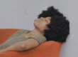 Black woman resting in orange chair during detox